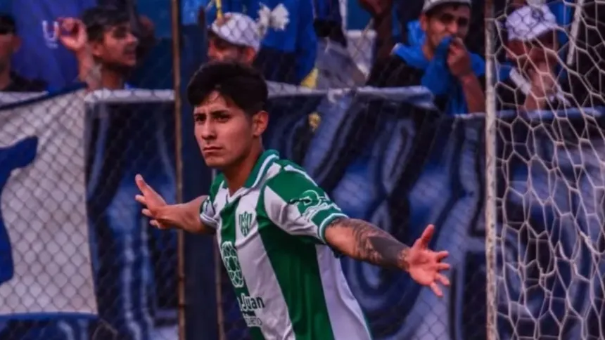 Un futbolista de verde y blanco celebra frente al arco, con hinchas detrás.