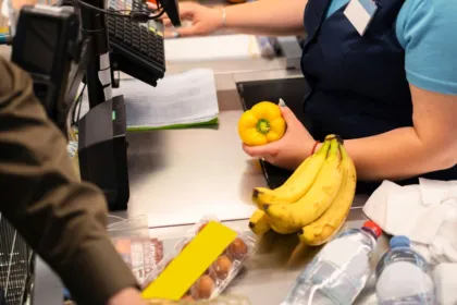 Una cajera pasa productos por la caja de un supermercado.