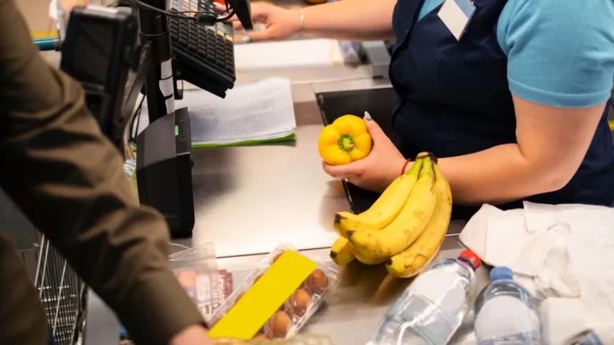 Una cajera pasa productos por la caja de un supermercado.