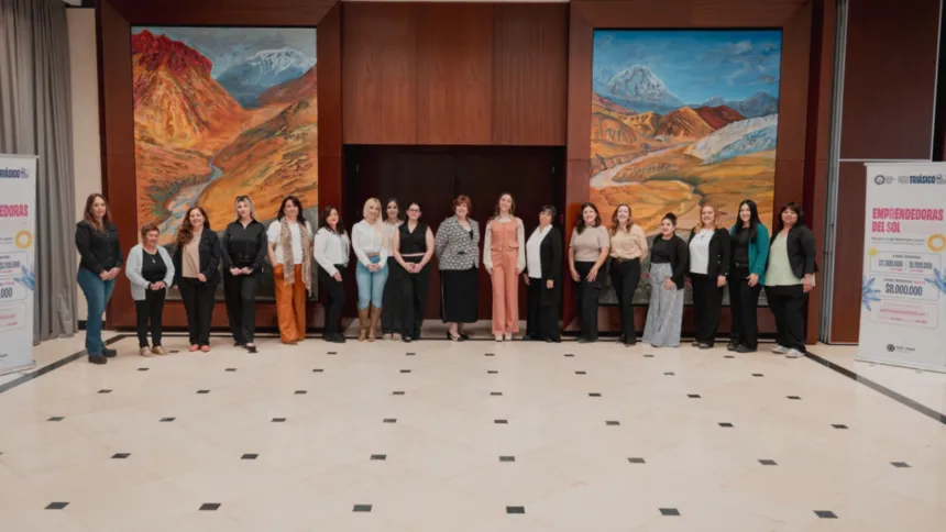 Mujeres reunidas en un salón junto a carteles de Emprendedoras del Sol.