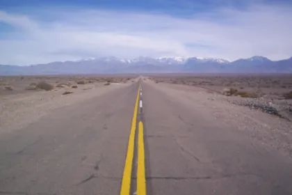 La Ruta Nacional 150 se extiende hacia montañas con nieve en las cumbres.