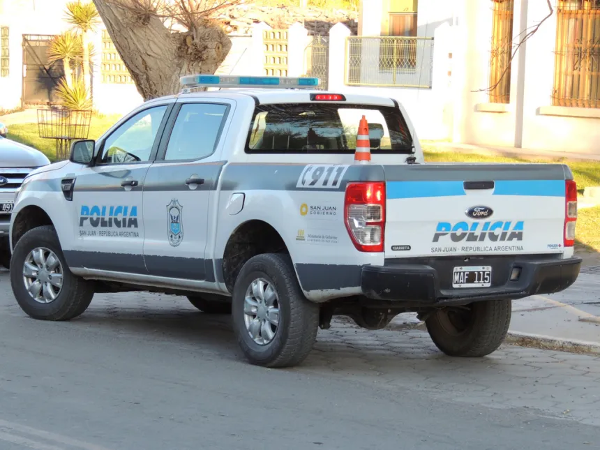 Camioneta de la Policía de San Juan estacionada junto a un edificio.