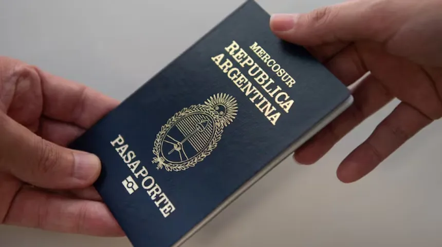 Dos manos sostienen un pasaporte argentino.