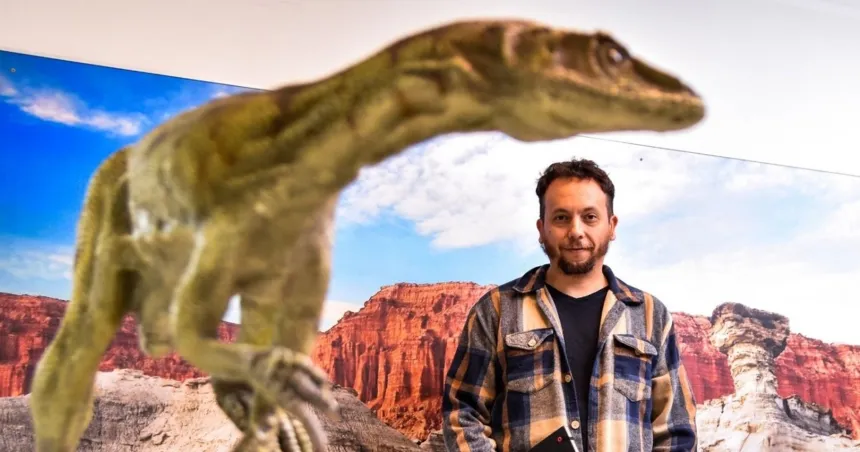 Nicolás Rodríguez, autor del guion, junto a la réplica de un dinosaurio frente a un paisaje de Ischigualasto.