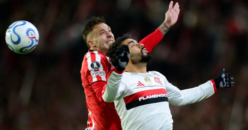 Jugadores de Flamengo y Estudiantes disputan una pelota en el campo.