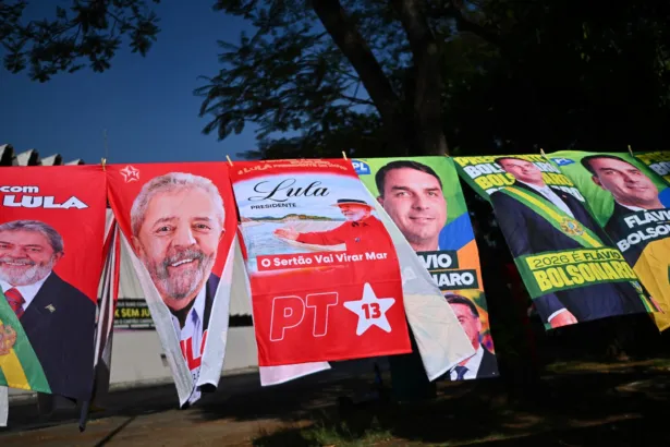 Carteles de campaña de Lula da Silva y Flávio Bolsonaro colgados junto a una calle.
