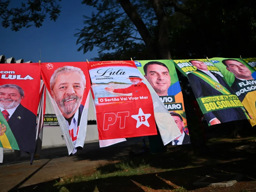 Carteles de campaña de Lula da Silva y Flávio Bolsonaro colgados junto a una calle.
