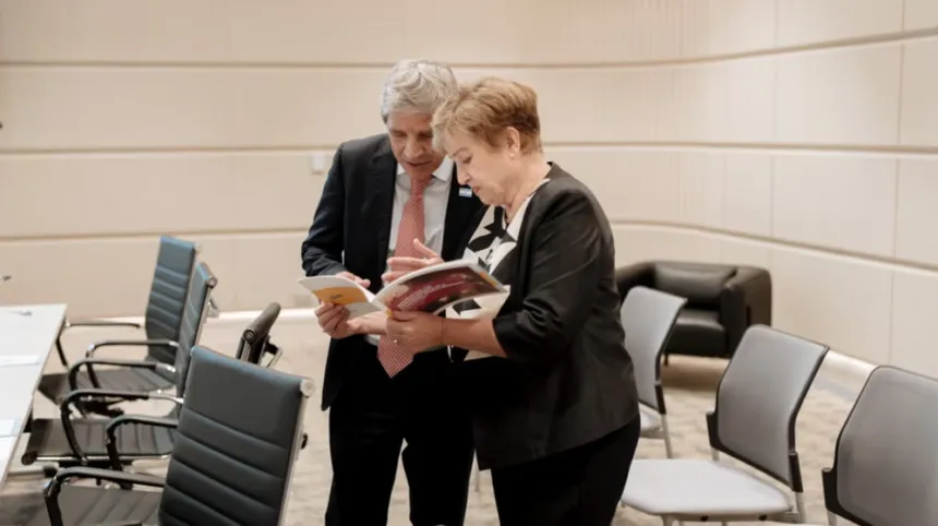 Dos adultos revisan un documento en una sala de reuniones.