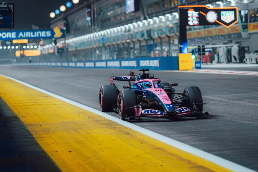 Un monoplaza Alpine rosa circula por el circuito nocturno de Singapur.