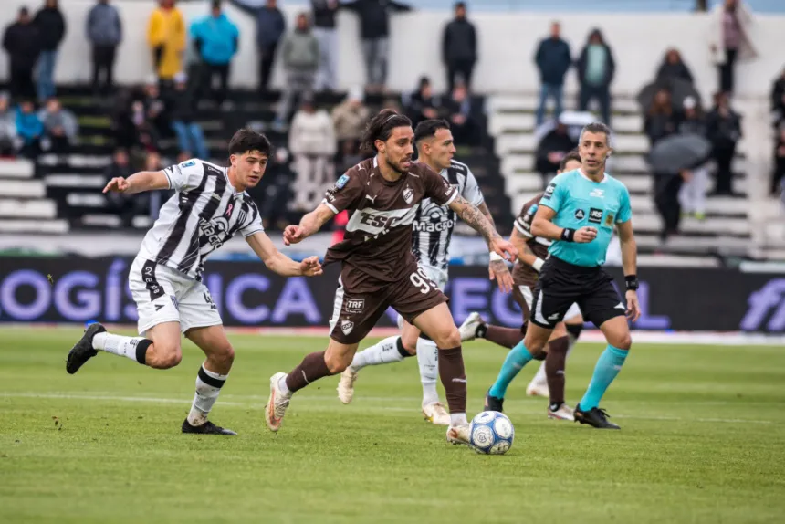 Jugadores de Gimnasia de Mendoza y Platense corren por la pelota durante el partido.