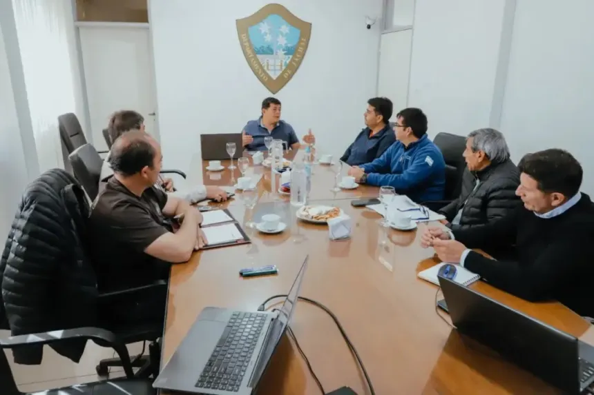 Un grupo de adultos participa de una reunión alrededor de una mesa.