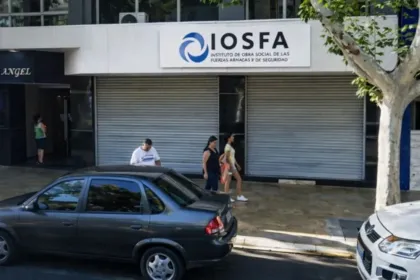 Farmacia de IOSFA con las persianas bajas y personas en la vereda.
