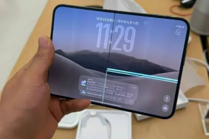 Una mano sostiene un teléfono plegable con líneas visibles en la pantalla.