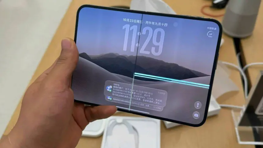 Una mano sostiene un teléfono plegable con líneas visibles en la pantalla.
