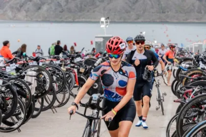 Triatletas con bicicletas en la zona de transición de una competencia.