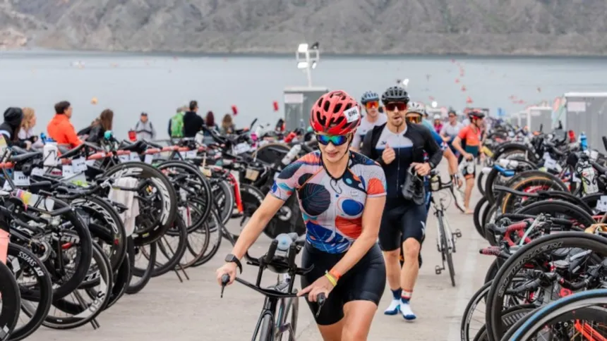 Triatletas con bicicletas en la zona de transición de una competencia.
