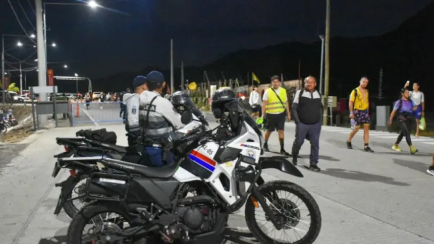Vallas y personal de seguridad en una calle cerrada al tránsito durante la noche.