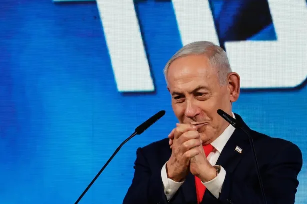 Benjamin Netanyahu, con traje y corbata roja, frente a dos micrófonos.
