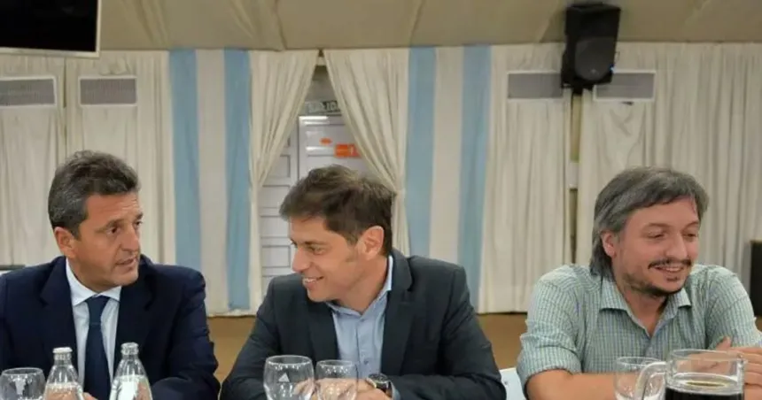 Massa, Kicillof y Máximo Kirchner conversan sentados a una mesa.