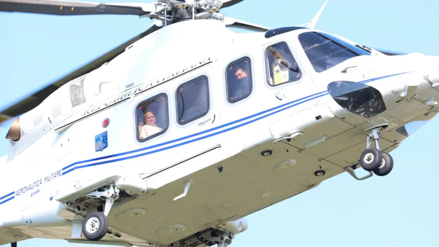 El papa León XIV, visible por una ventanilla, viaja en un helicóptero.