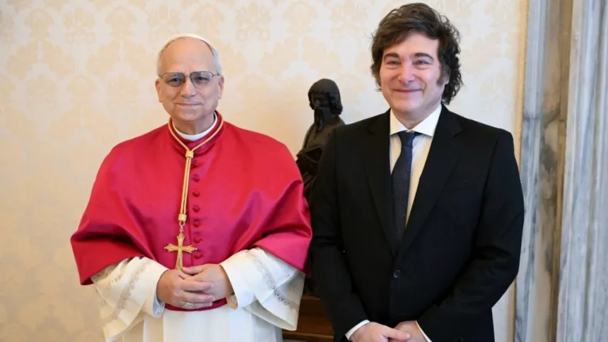 Javier Milei posa junto a un clérigo católico vestido de rojo.