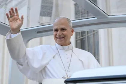 El papa León XIV saluda desde un vehículo.
