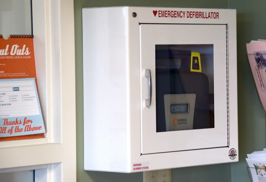 Un desfibrilador automático dentro de un gabinete de emergencia.