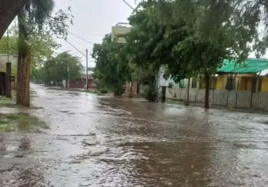 Una calle inundada por la lluvia, con agua frente a varias viviendas.