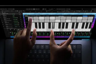 Manos usando la pantalla táctil de un MacBook con un programa de música