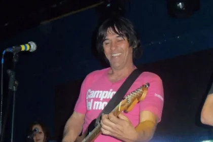 Un músico toca la guitarra en un escenario.