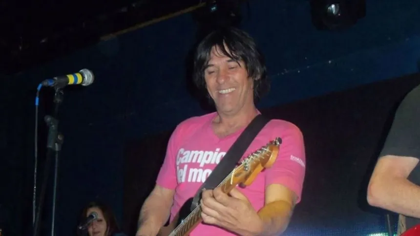 Un músico toca la guitarra en un escenario.
