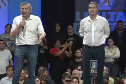 Máximo Kirchner habla con un micrófono junto a Jorge Capitanich en el acto del Día de la Lealtad en Resistencia.