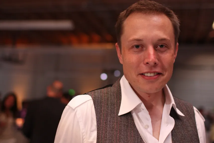 Elon Musk posa en un evento bajo techo.