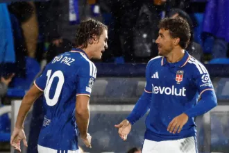 Nico Paz y un compañero del Como se saludan durante un partido bajo la lluvia.