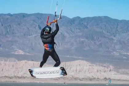 Una persona practica kitesurf frente a montañas en un paisaje de San Juan.