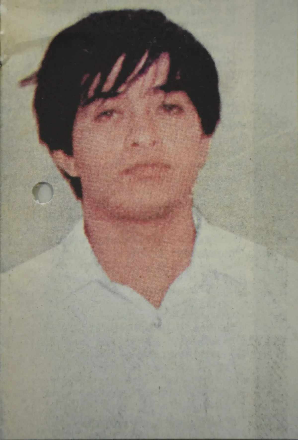Retrato de un joven de pelo oscuro y camisa clara, mirando a cámara.