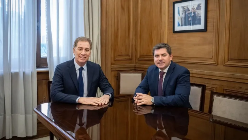 Marcelo Orrego y Diego Santilli conversan sentados a una mesa en una oficina.