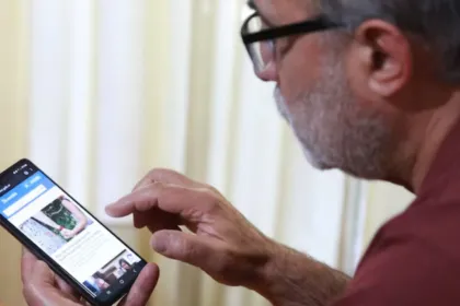 Un hombre mira una página en su celular.