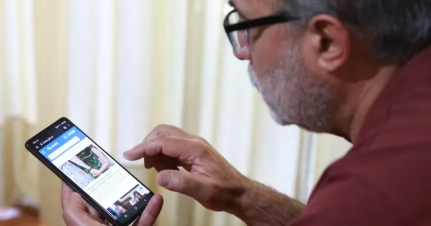 Un hombre mira una página en su celular.