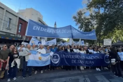 Manifestantes marchan con una pancarta de la Universidad Nacional de San Juan.