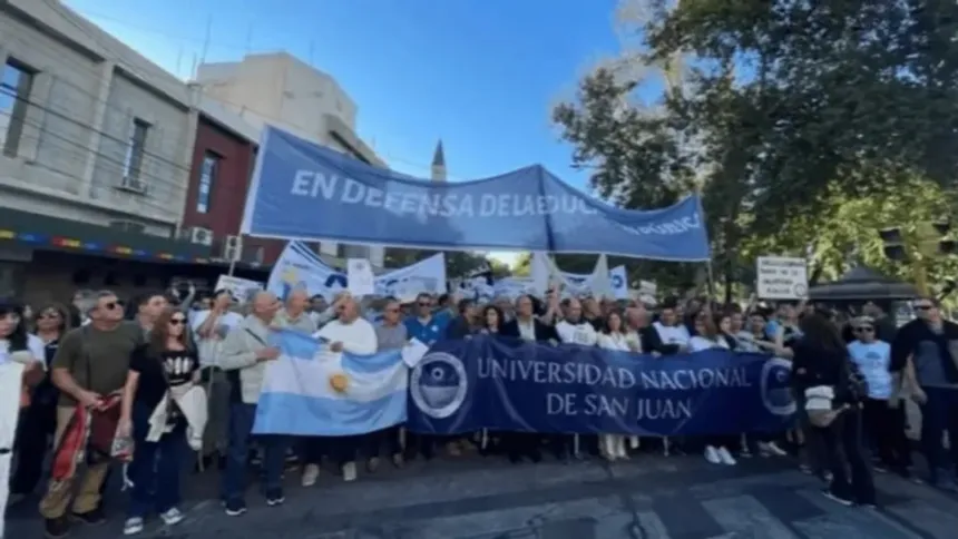 Manifestantes marchan con una pancarta de la Universidad Nacional de San Juan.