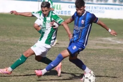 Dos jugadores disputan la pelota durante un partido de fútbol.