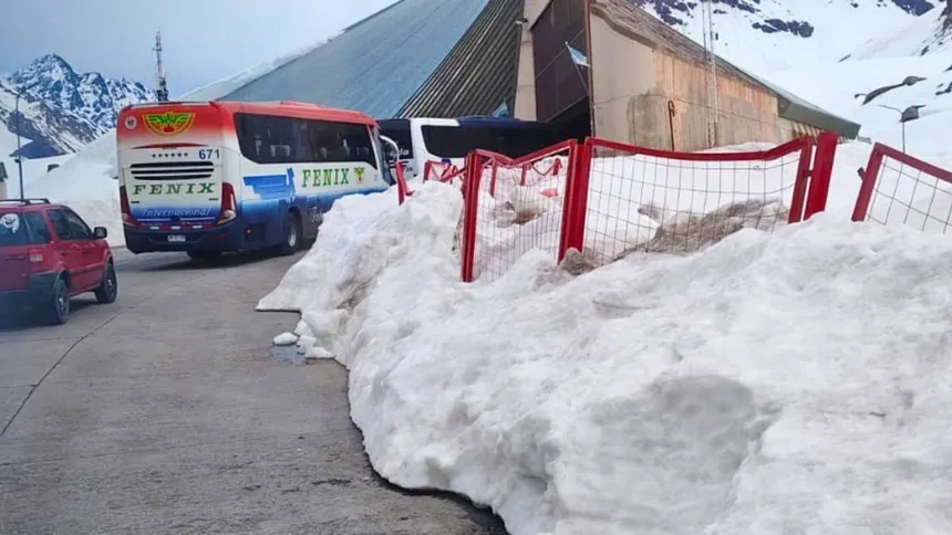 Un autobús y un automóvil junto a un edificio de control y nieve acumulada