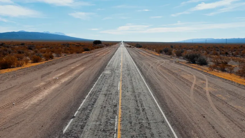 Una ruta atraviesa un paisaje árido y se extiende hacia las montañas.