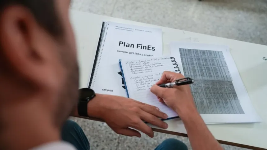 Una persona escribe en un formulario del Plan FinEs junto a otros documentos.