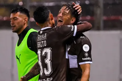 Dos jugadores de Platense se abrazan para celebrar durante un partido.