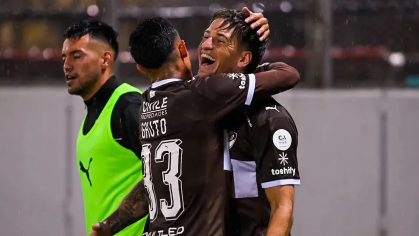 Dos jugadores de Platense se abrazan para celebrar durante un partido.