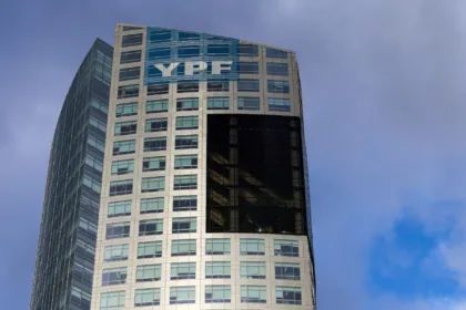 Edificio de oficinas con el logo de YPF bajo un cielo parcialmente nublado.