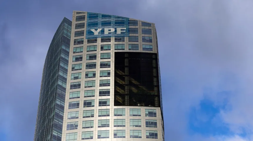 Edificio de oficinas con el logo de YPF bajo un cielo parcialmente nublado.