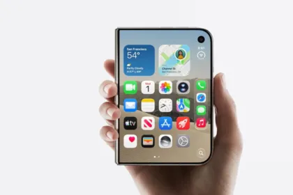 Una mano sostiene un teléfono Apple con la pantalla de inicio encendida.